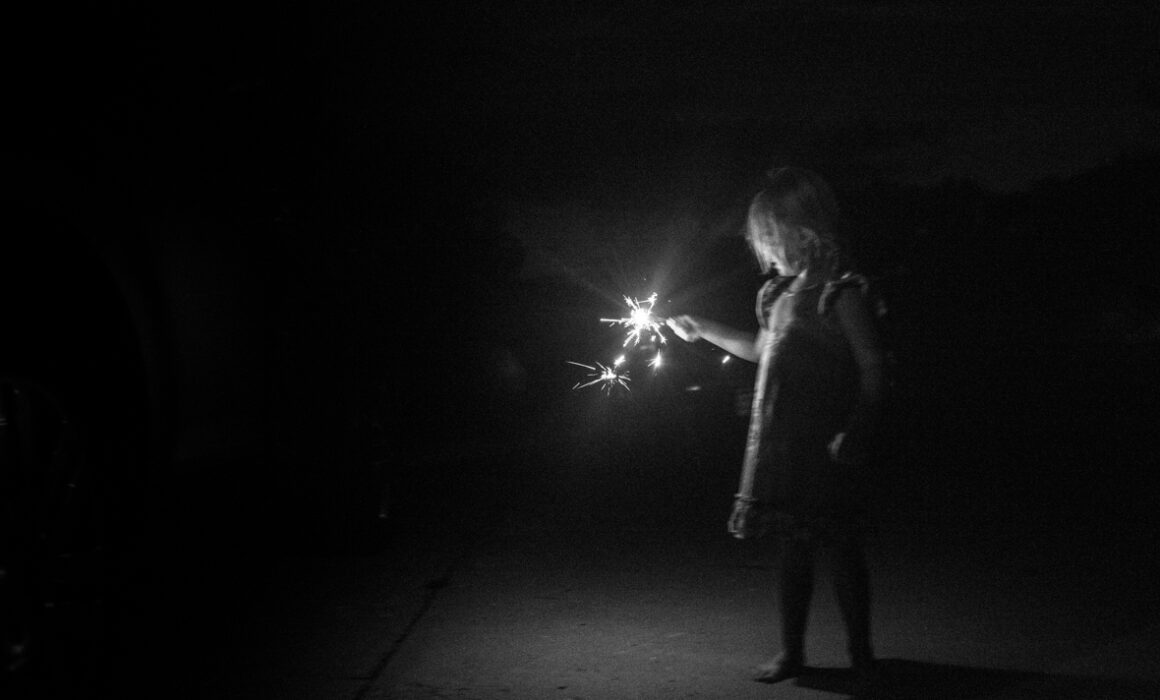 Child holding a sparkler on 4th of July